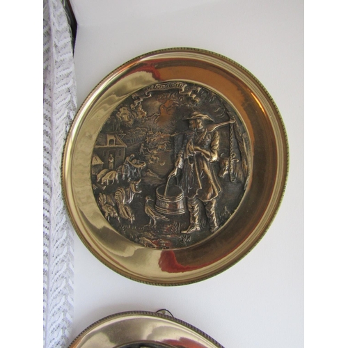 294 - Set of Four Heavy Brass Wall Chargers Depicting Trades People Each Approximately 13 Inches Diameter