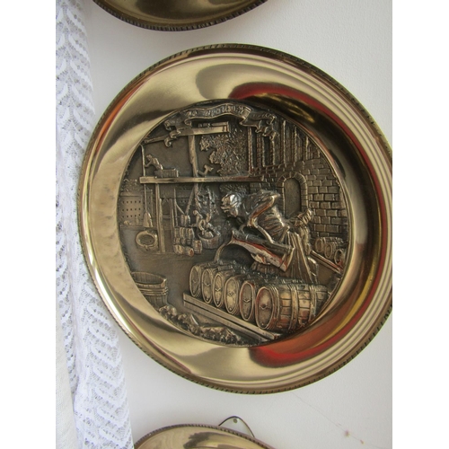 294 - Set of Four Heavy Brass Wall Chargers Depicting Trades People Each Approximately 13 Inches Diameter