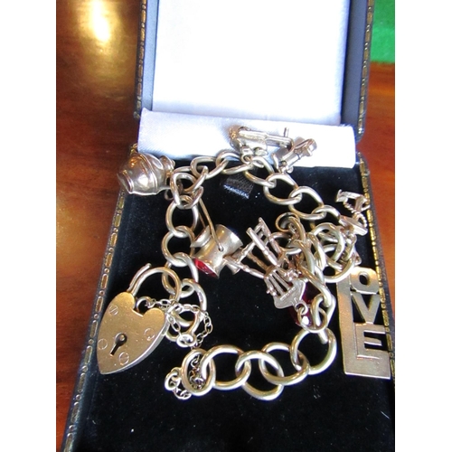 876 - 9 Carat Yellow Gold Charm Bracelet with Various Charms including Chair and Love Motifs