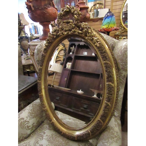 147 - Oval Form Gilded Wall Mirror with Upper Cartouche Decoration Approximately 32 Inches High