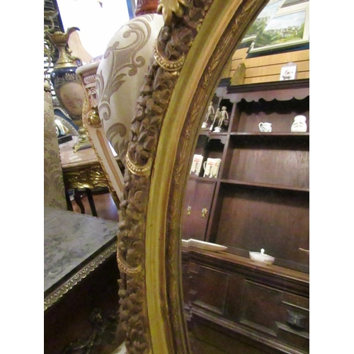 147 - Oval Form Gilded Wall Mirror with Upper Cartouche Decoration Approximately 32 Inches High