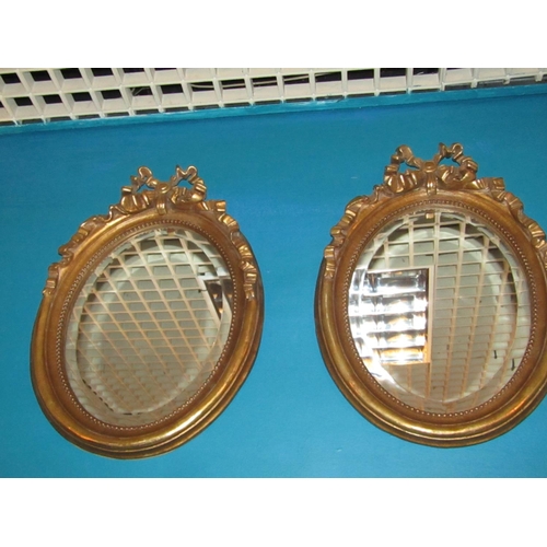 162 - Pair of Gilded Oval Form Wall Mirrors with Upper Ribbon Motif Decoration Each Approximately 22 Inche... 