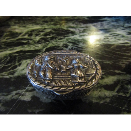 1190 - Silver Oval Form Pill Box Hinged Cover Embossed Figural Decoration