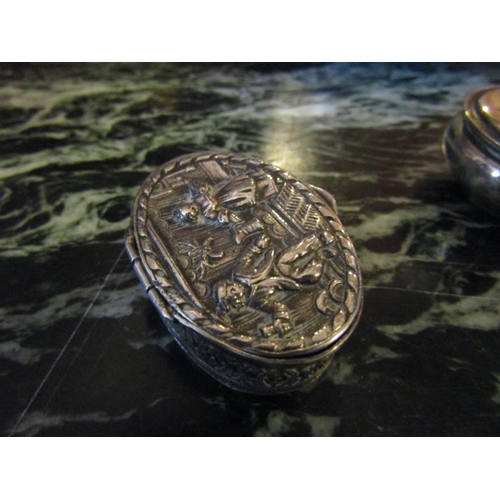 1190 - Silver Oval Form Pill Box Hinged Cover Embossed Figural Decoration