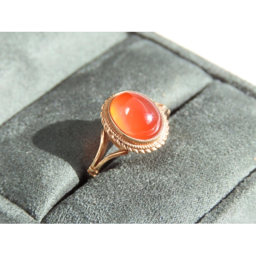 109 - Cabochon Oval Cut Red Gemstone Ring Mounted on 9 Carat Yellow Gold Band Basset Set Ring Size O