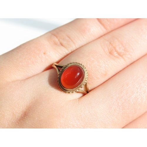 109 - Cabochon Oval Cut Red Gemstone Ring Mounted on 9 Carat Yellow Gold Band Basset Set Ring Size O