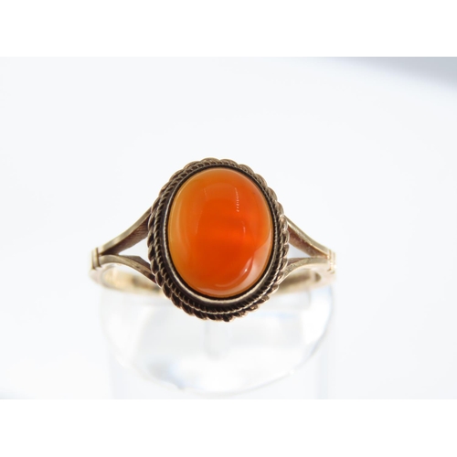 109 - Cabochon Oval Cut Red Gemstone Ring Mounted on 9 Carat Yellow Gold Band Basset Set Ring Size O