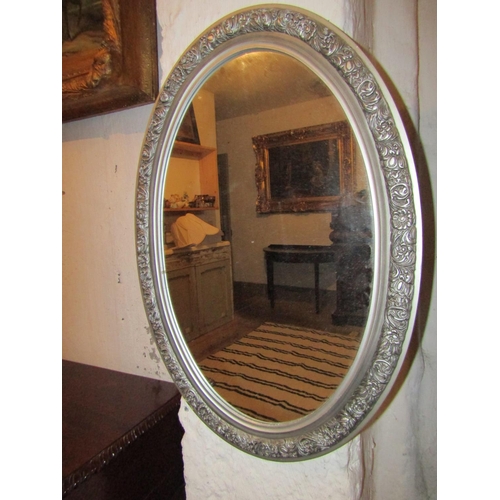 724 - Two Oval Form Wall Mirrors One Gilt Decorated Other Silvered Largest Approximately 22 Inches High