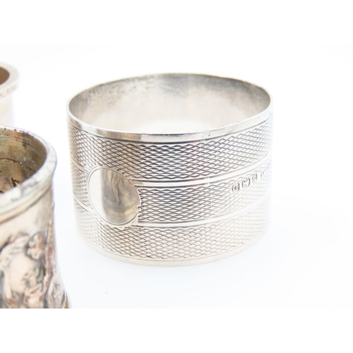 1162 - Three Silver Napkin Rings One with Cherub Motif Detailed