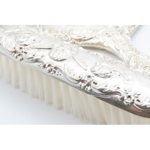 1195 - Four Piece Silver Mounted Hair Brushing Set with Hand Held Mirror Cherub Motif Decoration Throughout