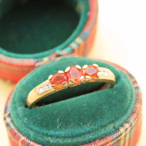 105 - Mandarin Garnet Three Stone with Diamond Mounted on 9 Carat Yellow Gold Band Ring Size R