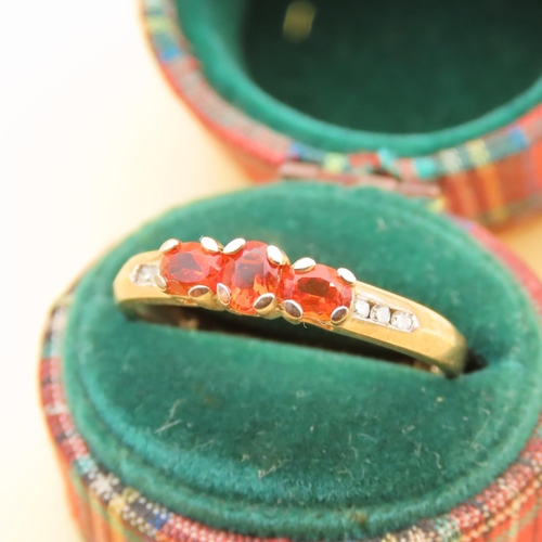 105 - Mandarin Garnet Three Stone with Diamond Mounted on 9 Carat Yellow Gold Band Ring Size R