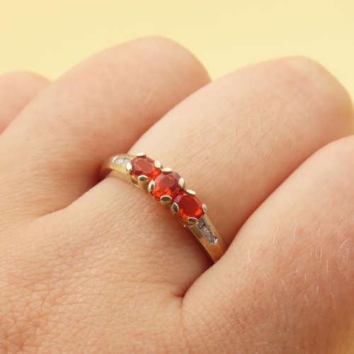 105 - Mandarin Garnet Three Stone with Diamond Mounted on 9 Carat Yellow Gold Band Ring Size R