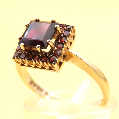 105 - Red Garnet Sharp Halo Set Ring Mounted on 9 Carat Yellow Gold Band Size N