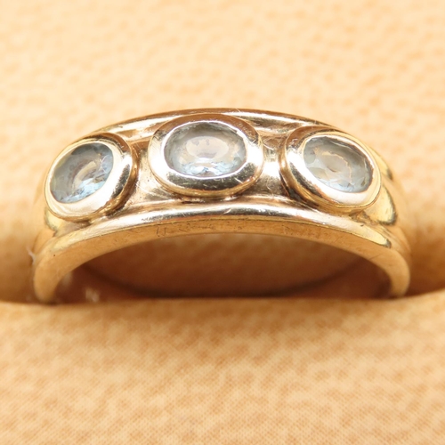 131 - Three Stone Aquamarine Ring Mounted on a 9 Carat Yellow Gold Band Size M