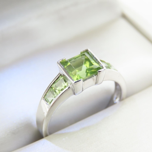 329 - Princess Cut Peridot Center Stone Ring with Further Peridot set to Shoulders Mounted on 9 Carat Whit... 