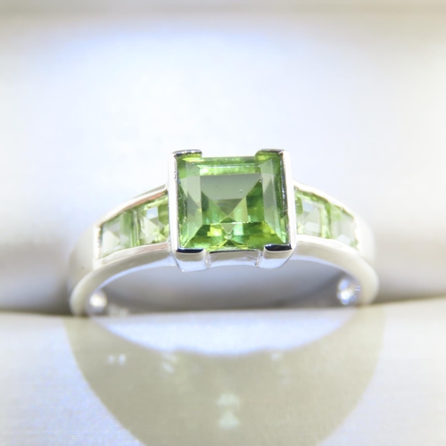 329 - Princess Cut Peridot Center Stone Ring with Further Peridot set to Shoulders Mounted on 9 Carat Whit... 