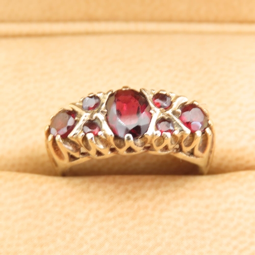 557 - Seven Stone Red Garnet Ring Mounted on 9 Carat Yellow Gold Band Size L