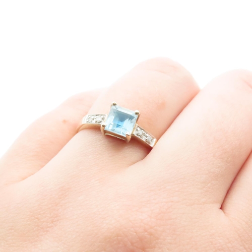 1635 - Princess Cut Blue Topaz Ring with Further Diamonds Set to Shoulder Mounted in 9 Carat Yellow Gold Ri... 