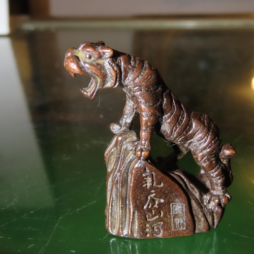 258 - Eastern Bronze Scroll Weight Tiger on Rock Signed with Characters to Side Approximately 6cm High