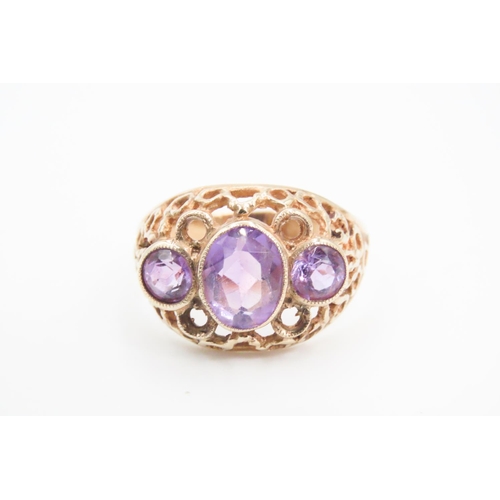 74 - Three Stone Amethyst Ladies Ring Mounted on 9 Carat Yellow Gold Openwork Scroll Setting Ring Size O