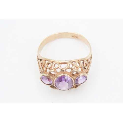 74 - Three Stone Amethyst Ladies Ring Mounted on 9 Carat Yellow Gold Openwork Scroll Setting Ring Size O