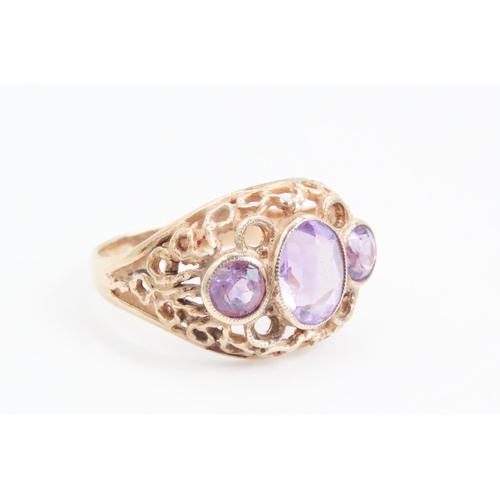 74 - Three Stone Amethyst Ladies Ring Mounted on 9 Carat Yellow Gold Openwork Scroll Setting Ring Size O