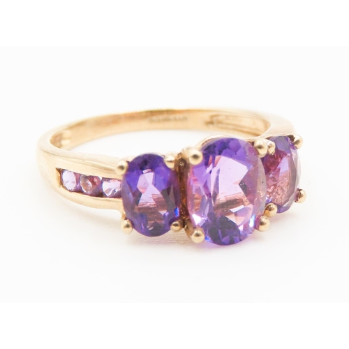 Three Stone Oval Cut Amethyst set Ring Mounted in 9 Carat Yellow Gold Ring Size Q