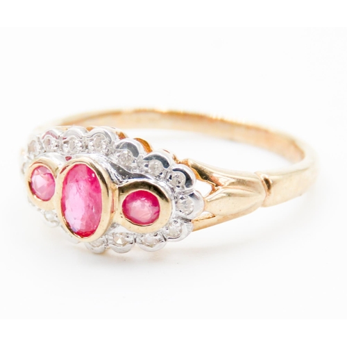 76 - Three Stone Ruby Set Ring Diamond Set Halo Surround Mounted in 9 Carat Yellow Gold Ring Size O