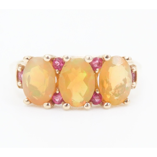 166 - Three Stone Opal Ring with further Ruby Insets Mounted in 10 Carat Yellow Gold Ring Size P