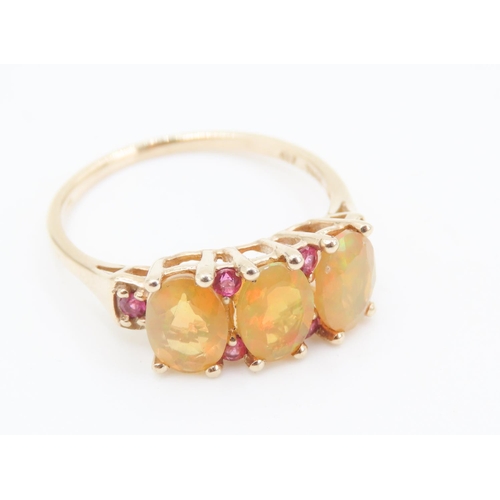 166 - Three Stone Opal Ring with further Ruby Insets Mounted in 10 Carat Yellow Gold Ring Size P