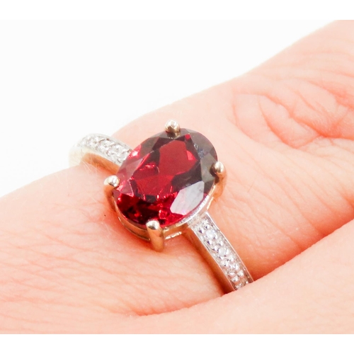 228 - Oval Cut Red Garnet Centre Stone Ring Mounted in 9 Carat Yellow Gold Further Diamonds Set to Shoulde... 