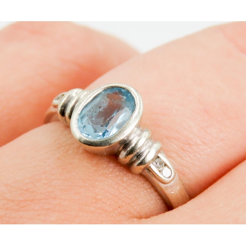 325 - Oval Bezel Set Sky Blue Topaz Ring Mounted in 9 Carat White Gold Further Diamond Set to Shoulders Ri... 