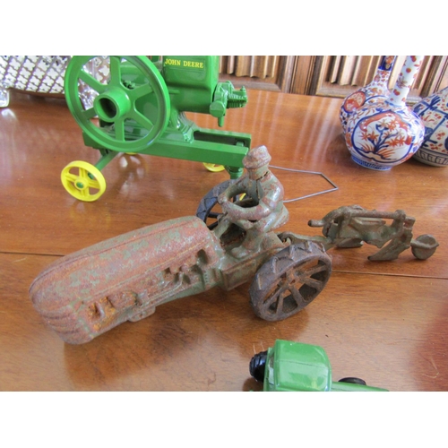 856 - John Deere Cast Iron Tractors One with Plough Four Pieces in Lot