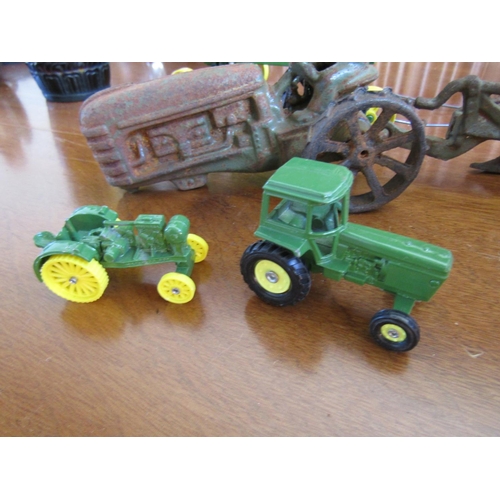 856 - John Deere Cast Iron Tractors One with Plough Four Pieces in Lot