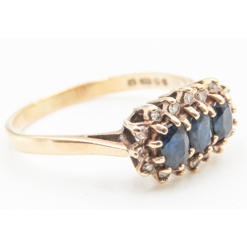 145 - Sapphire Three Stone Ring with Diamond Set Surround Mounted in 9 Carat Yellow Gold Ring Size O