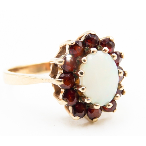 291 - Opal Centre Stone Ring with Red Garnet Set Halo Surround Mounted in 9 Carat Yellow Gold Ring Size K