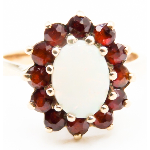 291 - Opal Centre Stone Ring with Red Garnet Set Halo Surround Mounted in 9 Carat Yellow Gold Ring Size K