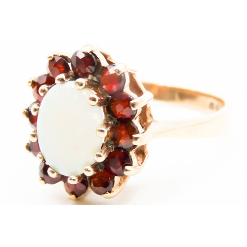 291 - Opal Centre Stone Ring with Red Garnet Set Halo Surround Mounted in 9 Carat Yellow Gold Ring Size K