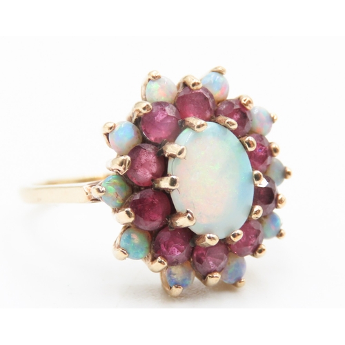 375 - Opal Centre Stone Ring with Further Ruby and Opal Halo Setting Mounted in 9 Carat Yellow Gold Ring S... 