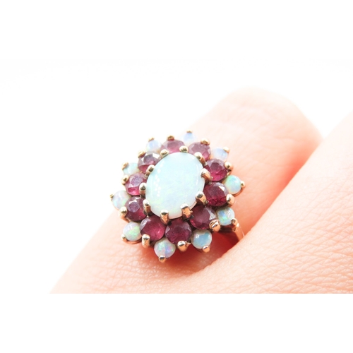 375 - Opal Centre Stone Ring with Further Ruby and Opal Halo Setting Mounted in 9 Carat Yellow Gold Ring S... 