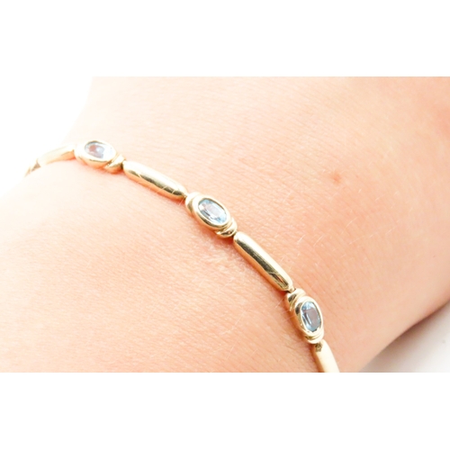 516 - Eight Stone Blue Topaz Bezel Set Bracelet Mounted in 9 Carat Yellow Gold 17cm Long