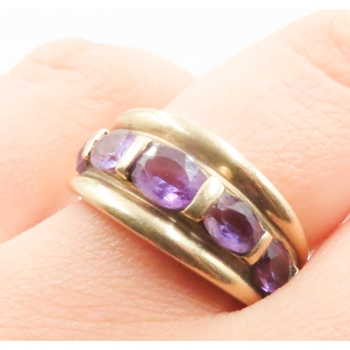 65 - Amethyst Five Stone Half Bezel Set Ring Mounted in 9 Carat Yellow Gold Ring Size P