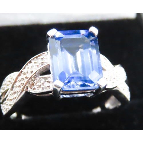 88 - Emerald Cut Tanzanite Four Claw Set Ring Braid Motif Band Mounted in 10 Carat White Gold Ring Size O