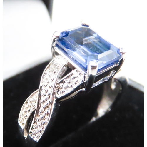 88 - Emerald Cut Tanzanite Four Claw Set Ring Braid Motif Band Mounted in 10 Carat White Gold Ring Size O