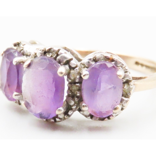 234 - Three Stone Amethyst Set Ring with Further Diamond Insets Mounted in 9 Carat Yellow Gold Ring Size P