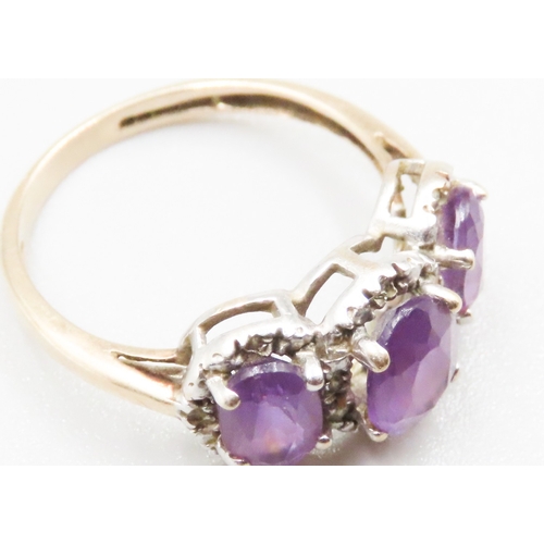 234 - Three Stone Amethyst Set Ring with Further Diamond Insets Mounted in 9 Carat Yellow Gold Ring Size P