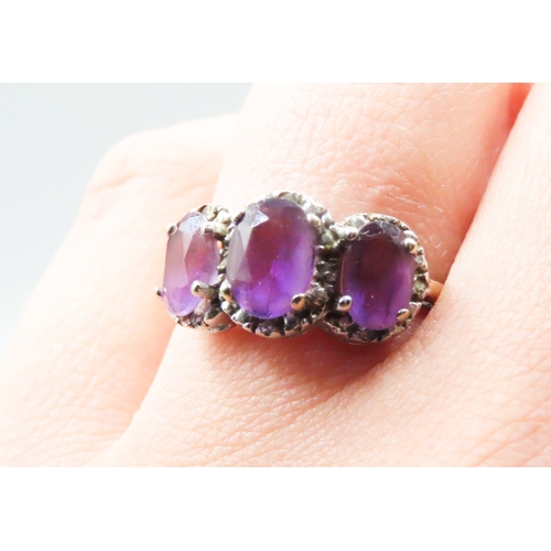 234 - Three Stone Amethyst Set Ring with Further Diamond Insets Mounted in 9 Carat Yellow Gold Ring Size P