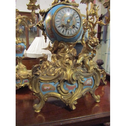 1107 - French Three Piece Clock Suite with Upper Cherub Motif Decoration Porcelain Inset Includes Two Rocco... 