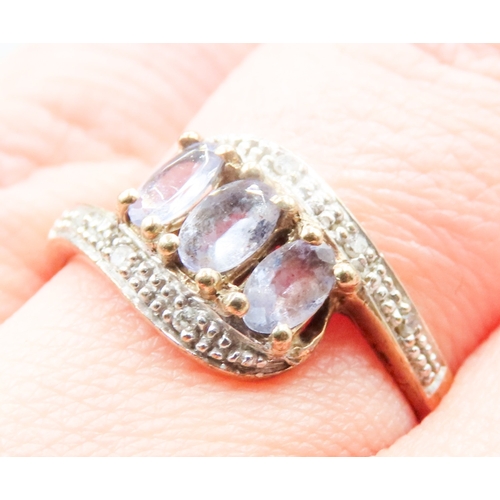 136 - Pale Tanzanite Three Stone Wrap Around Form Ring with Diamond Inset to Shoulders Mounted on 9 Carat ... 